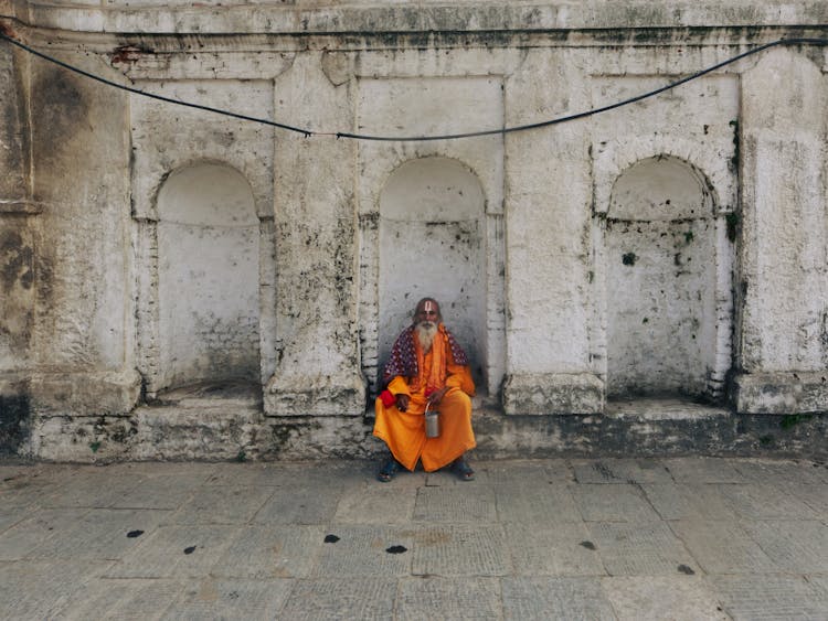 Elderly Monk In Front Of Building