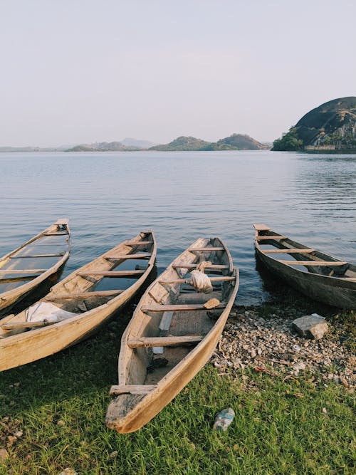 Brown Wooden Boats on Shore near Body of Water