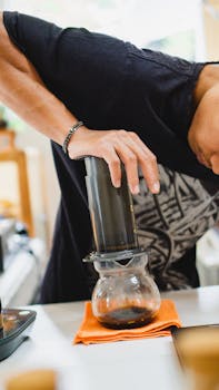 Close-up of brewing coffee using an Aeropress in an Indonesian café setting.