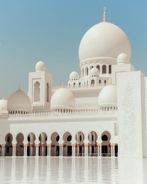 Free Majestic white domes and arches of Sheikh Zayed Grand Mosque in Abu Dhabi under a clear sky. Stock Photo