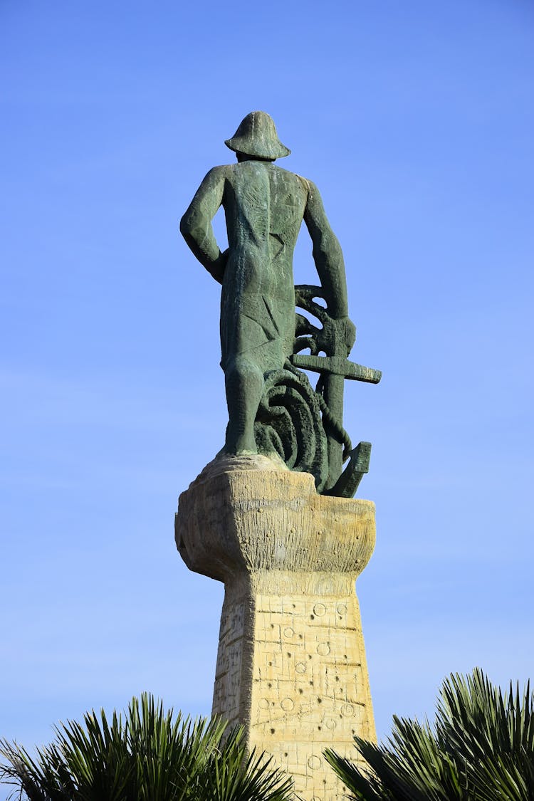 Sculpture On Pedestal On Blue Sky Background