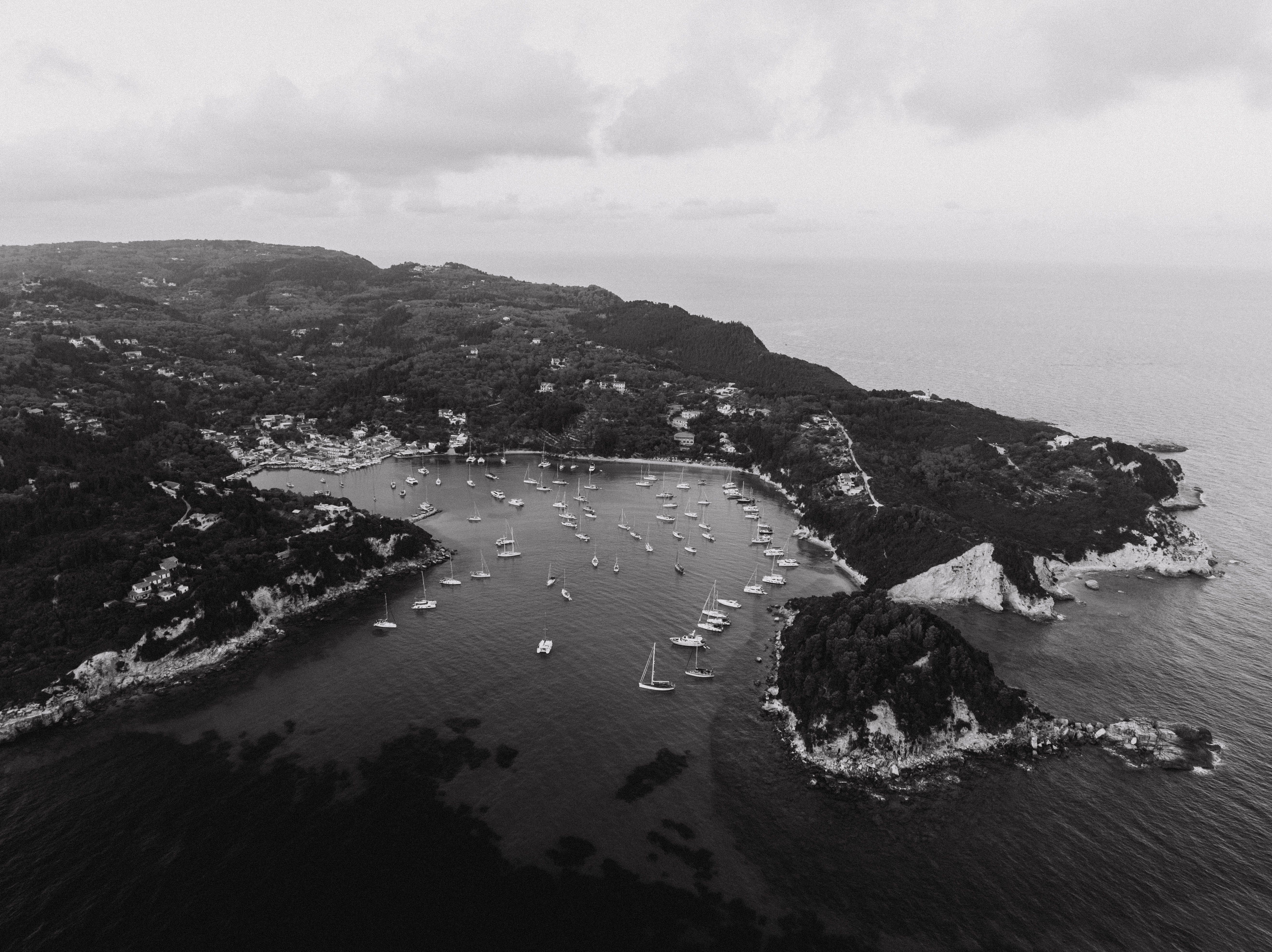 Unbeatable 5 hours from Kassandra: W Sithonia Coves & Islands Yacht Sailing Review 2026 - Black and white aerial shot of sailboats in a coastal bay in Greece, surrounded by lush landscapes.