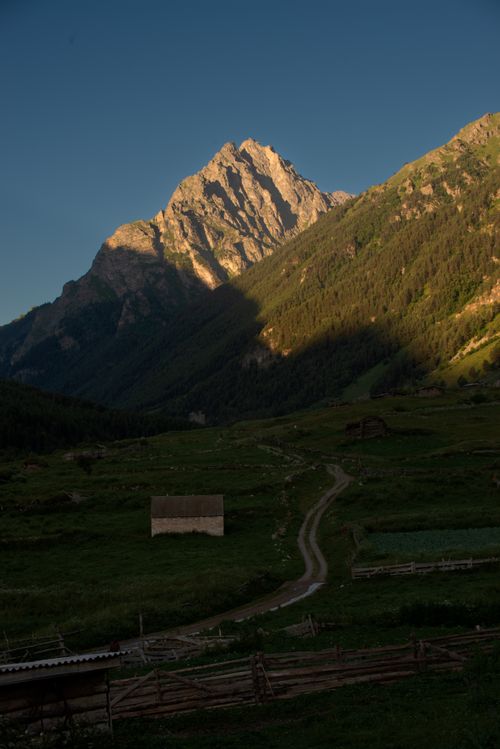 Free Stunning view of a mountain under the golden hour light with a winding countryside road. Stock Photo