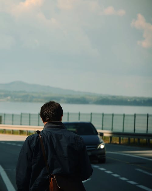 Man with Backpack Walking on Road