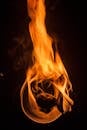 黑暗背景下，充满活力的火焰与燃烧的木材构成了一幅戏剧性特写