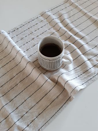 Striped ceramic mug on linen, photo by Misa S. on Pexels