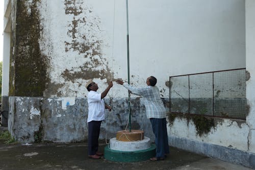 Men Hosting Flag on Pole