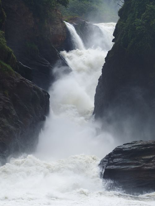 Free Powerful waterfall cascading through lush rocky gorge, showcasing nature's beauty and raw energy. Stock Photo