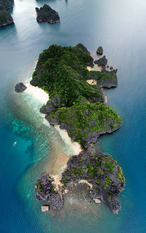 Free Stunning aerial shot of a lush tropical island surrounded by clear blue waters. Stock Photo
