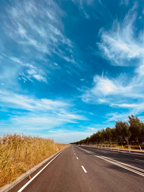 Free Stunning open road in Lvjuhe Town, Tianjin with clear blue skies and white clouds. Stock Photo