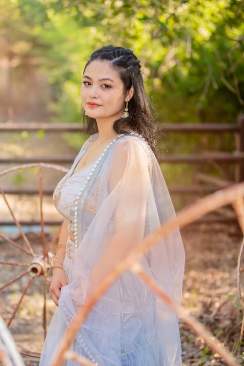 Woman in White Dress Standing Near Brown Wooden Fence