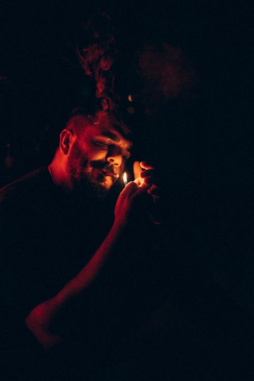 Man Lighting Cigarette in Darkness