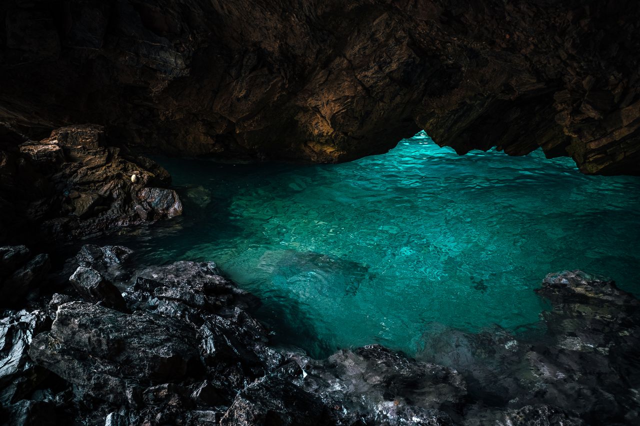 explore the serene blue waters within a stunning geological cave forma