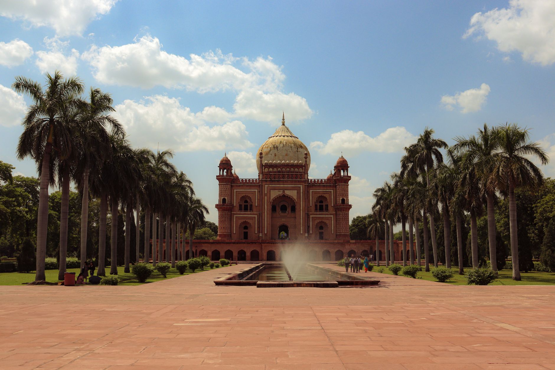 A scenic view of Safdarjung Tomb in New Delhi with palm trees and a fountain under a bright blue sky., travel destination in India, where a local eSIM keeps you connected