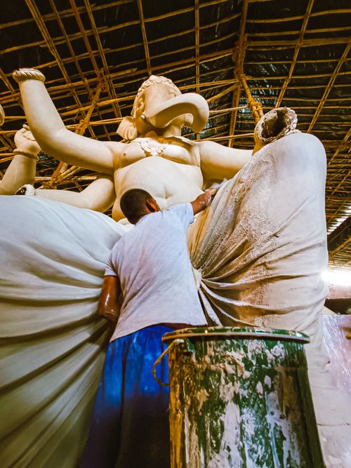 Free A craftsman meticulously sculpts a large Ganesh idol in a traditional Mumbai workshop. Stock Photo