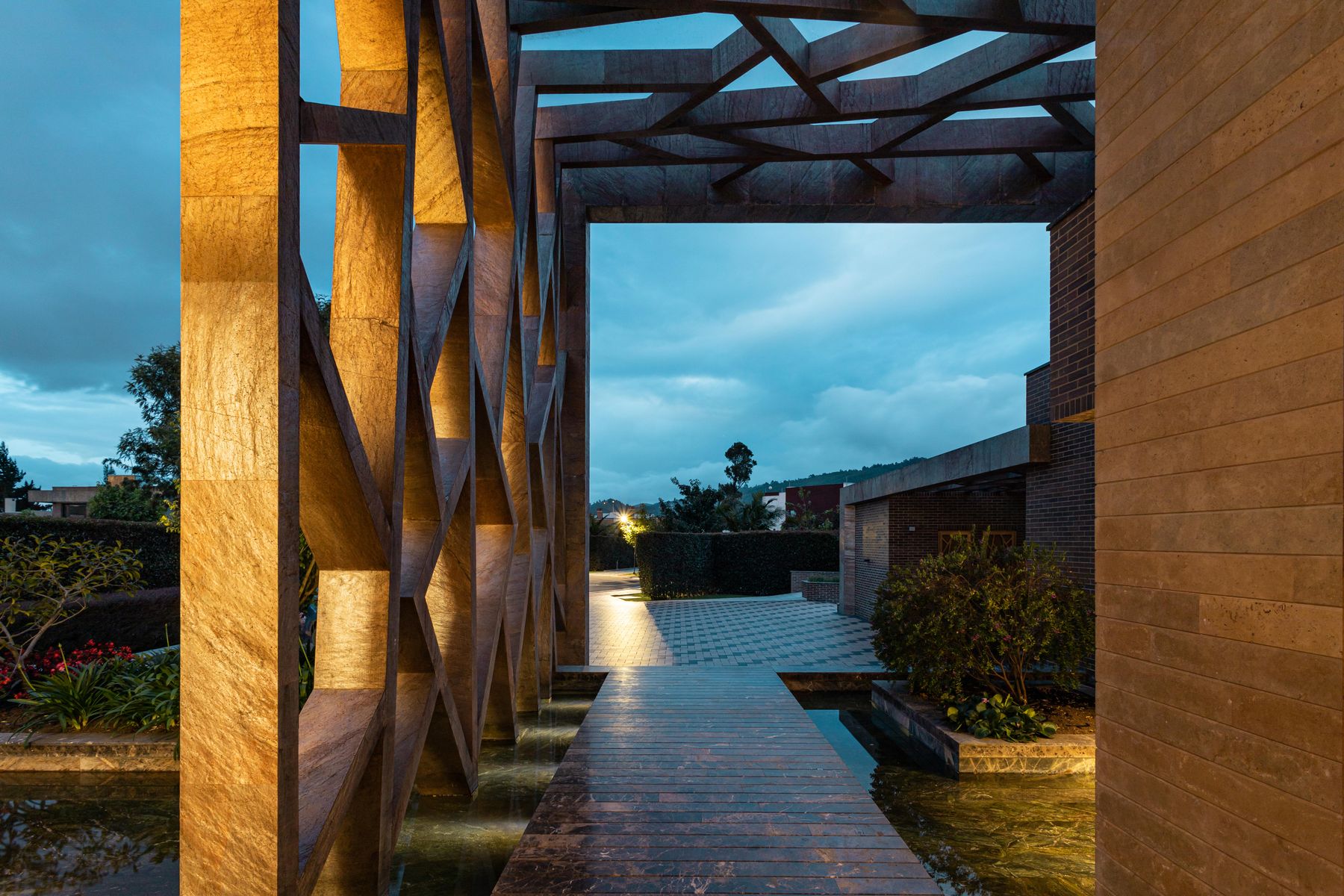 A modern terrace at dusk with a pool and warm lighting