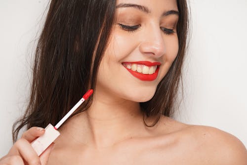 A Topless Woman Holding a Red Lipstick