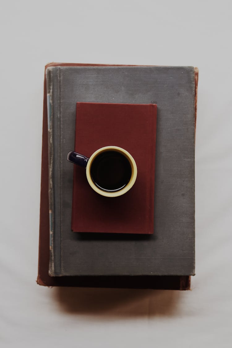 Top View Of A Cup Of Black Coffee On A Stack Of Books