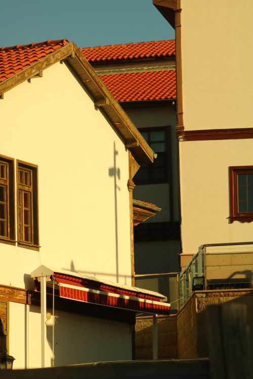 Free Sunlit buildings featuring red rooftops and wood accents, captured with a Canon EOS 750D. Stock Photo