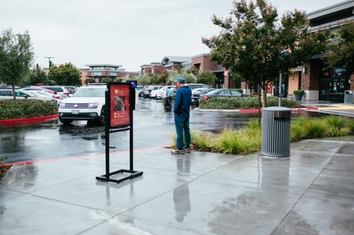 Free A shopping center parking lot after rain featuring wet pavement and parked cars. Stock Photo