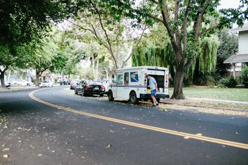 A Man Walking Beside USPS Mail Van
