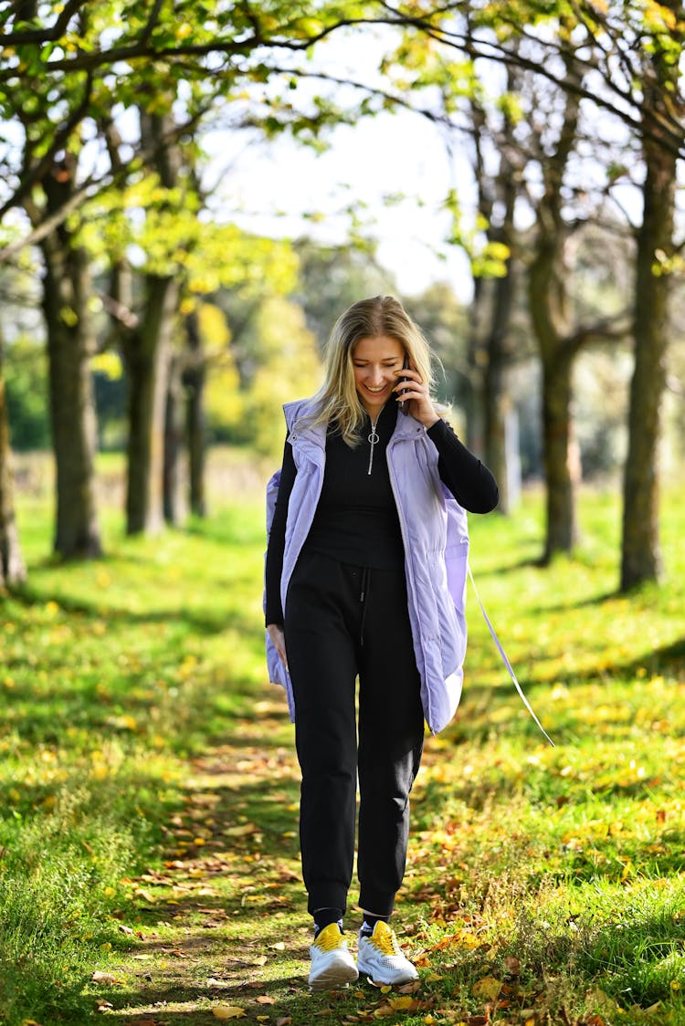 Woman Walking And Talking Through A Phone On The Rural Path