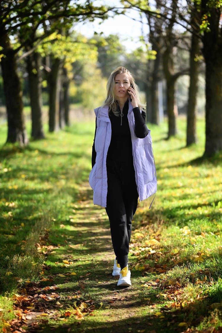 Woman Walking Path In Park Talking On Phone