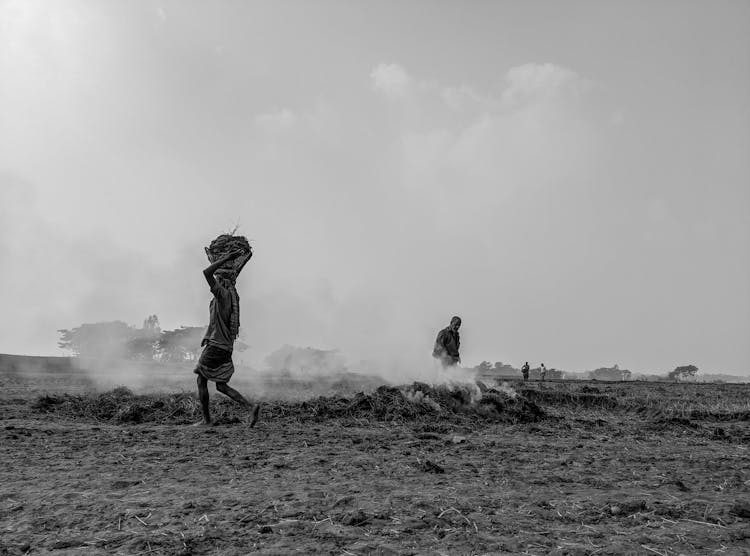 Person Carrying A Load On Head On A Field