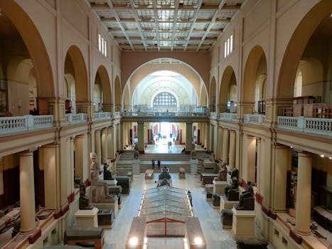 Wide view of the Egyptian Museum's main hall showcasing ancient sculptures and architecture.