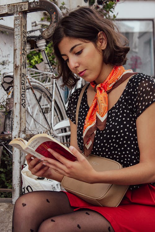 Woman in a Polka Dot Top Reading a Book