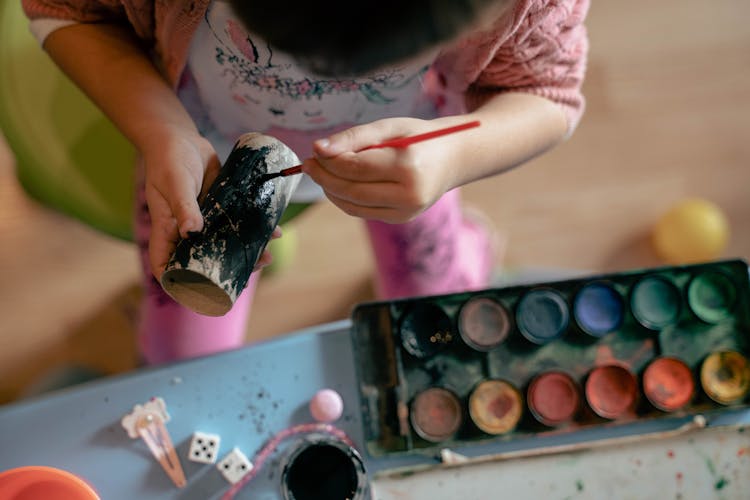 A Kid Painting A Cardboard