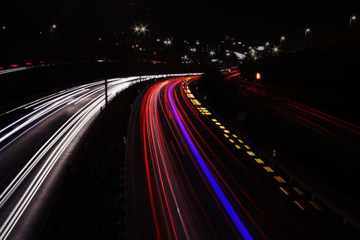 Vibrant long exposure of light trails on a busy highway at night showcasing urban energy.