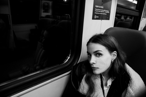 Free Black and white photo of a woman reflecting through a train window during a night journey. Stock Photo