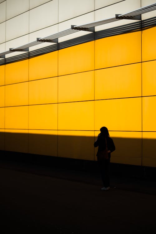Бесплатное стоковое фото с вертикальный выстрел, желтая стена, женщина