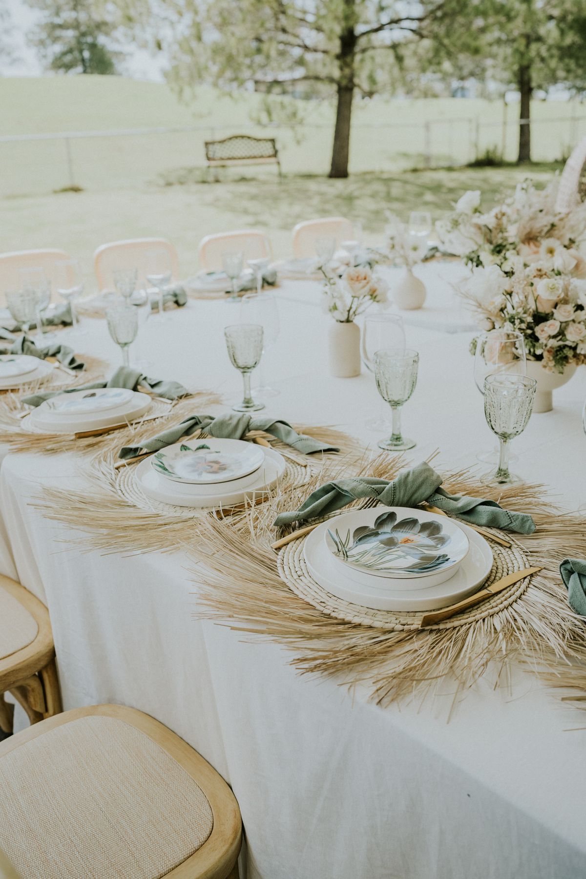 Chic outdoor wedding table with floral decor and vintage glassware, perfect for spring ceremonies. Stock Photo.