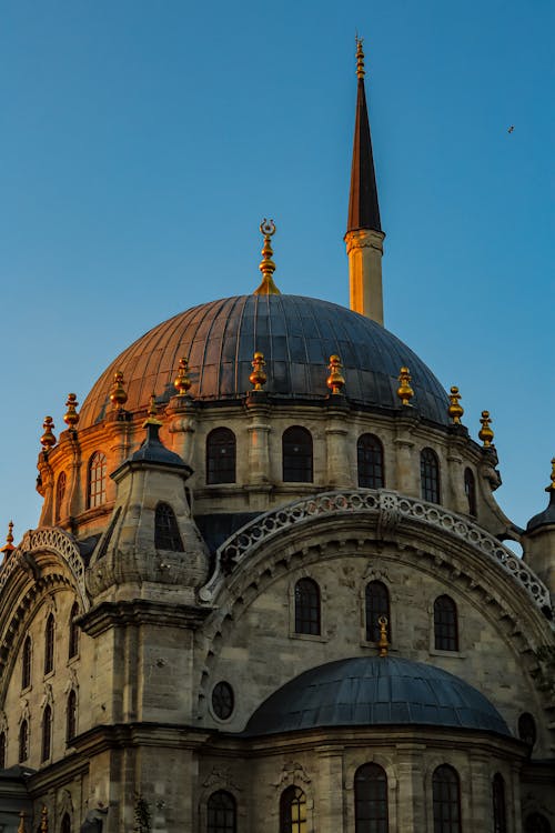 Closeup of a Mosque with a Cupola and Minaret against Blue Sky