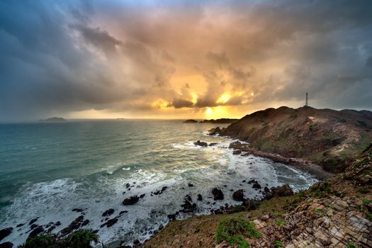 Stunning rocky coastline with dramatic sky at sunset, capturing nature's raw beauty.