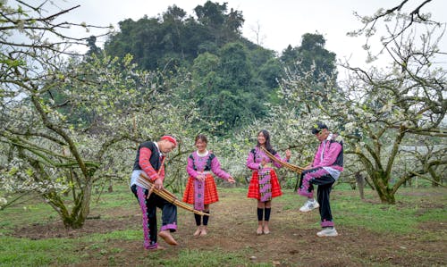 People in Traditional Costumes Dancing in Garden