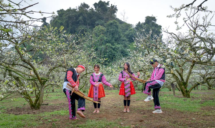 People In Traditional Costumes Dancing In Garden