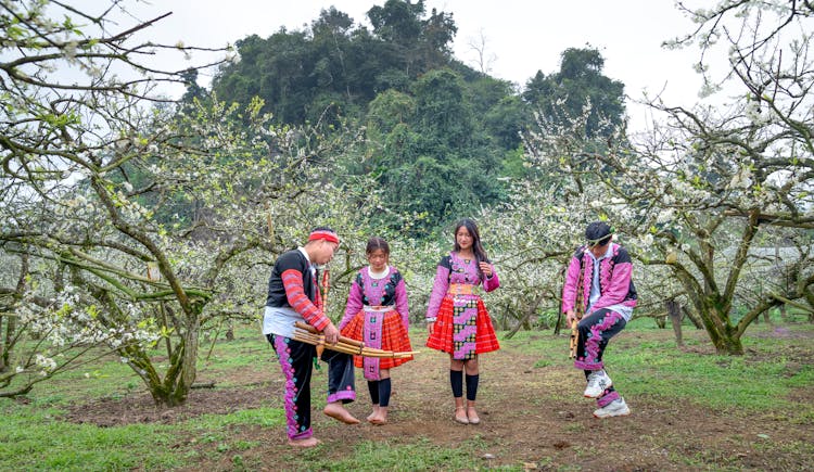 People In Traditional Costumes Dancing In Garden