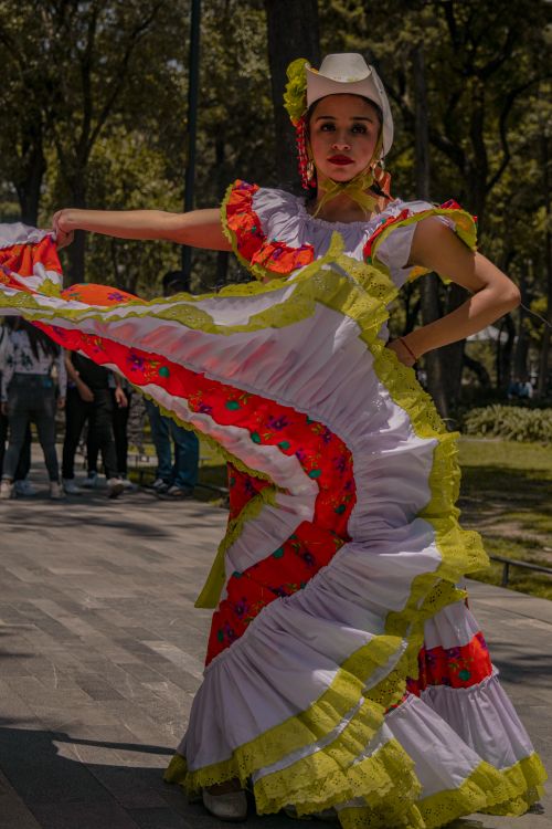 Free A woman performs a traditional Mexican dance in a vibrant dress outdoors, capturing cultural heritage. Stock Photo