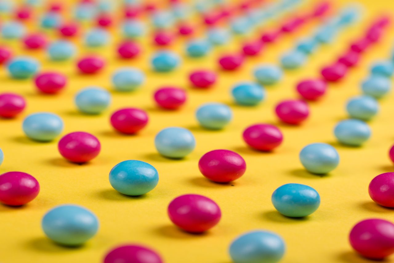 vibrant pink and blue candies on a yellow surface in a macro shot crea