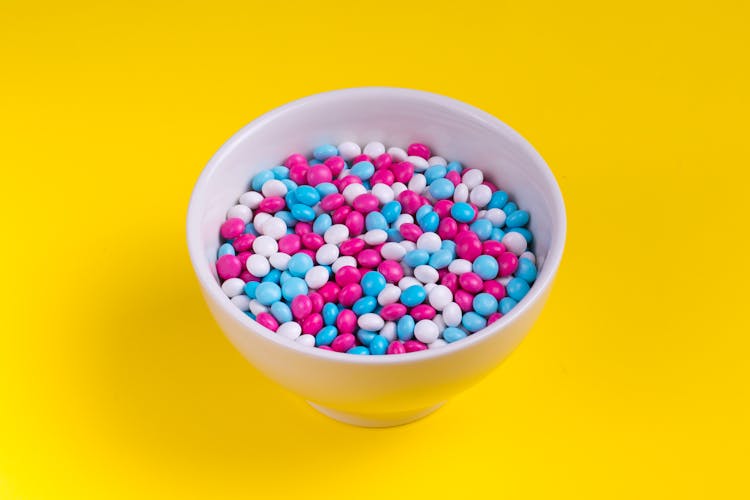 White, Pink, And Blue Candies In Bowl