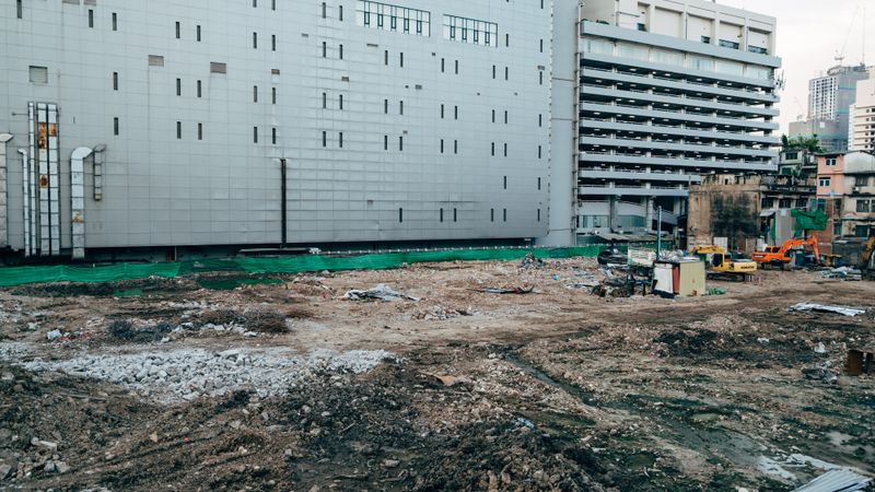 A construction site with surrounding modern buildings in an urban setting.
