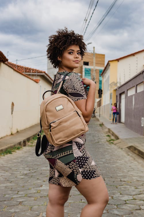 Woman in Black, Beige, and Green Dress With Brown Backpack