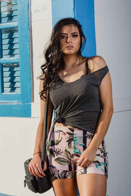 Free Woman in Grey Sleeveless Top Leaning on Wall Stock Photo