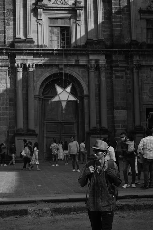 Grayscale Photo of People on the Street near Church Building
