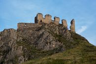 Explore the ancient Trascău Fortress ruins perched atop a rocky hill in Romania's scenic landscape.