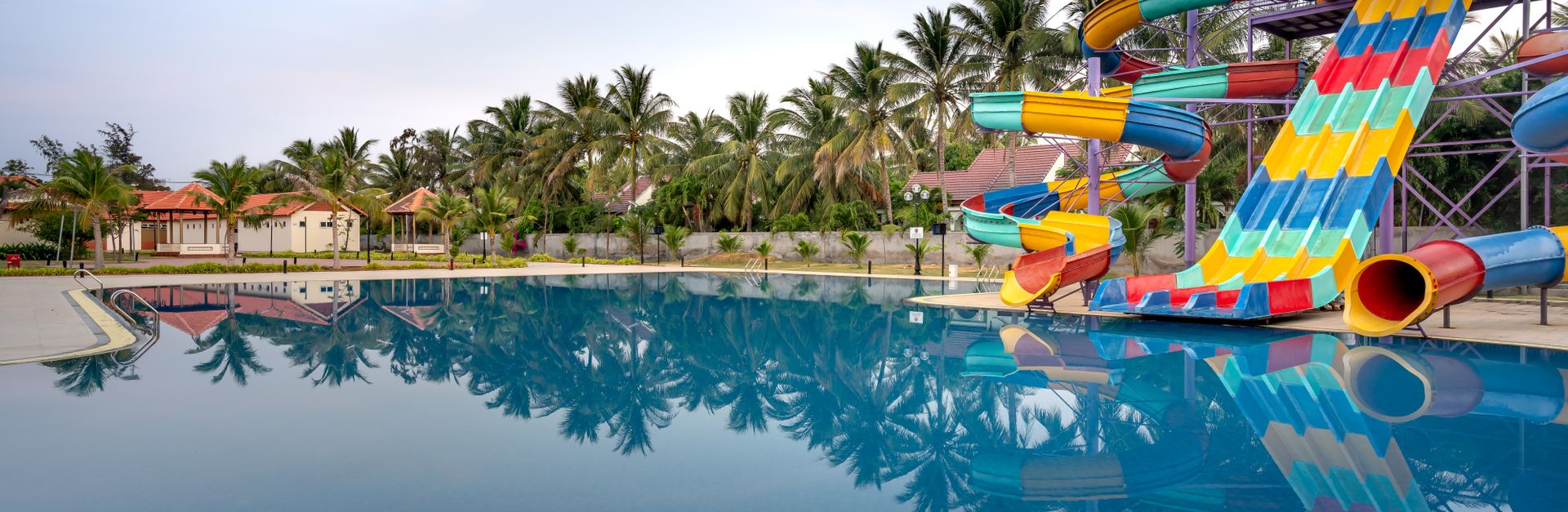 Colorful water slides and a serene pool at a summer water park for relaxation and fun.