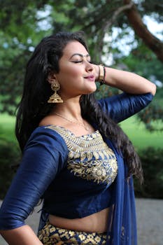 一位身着传统蓝金服饰的女性在户外摆姿留影